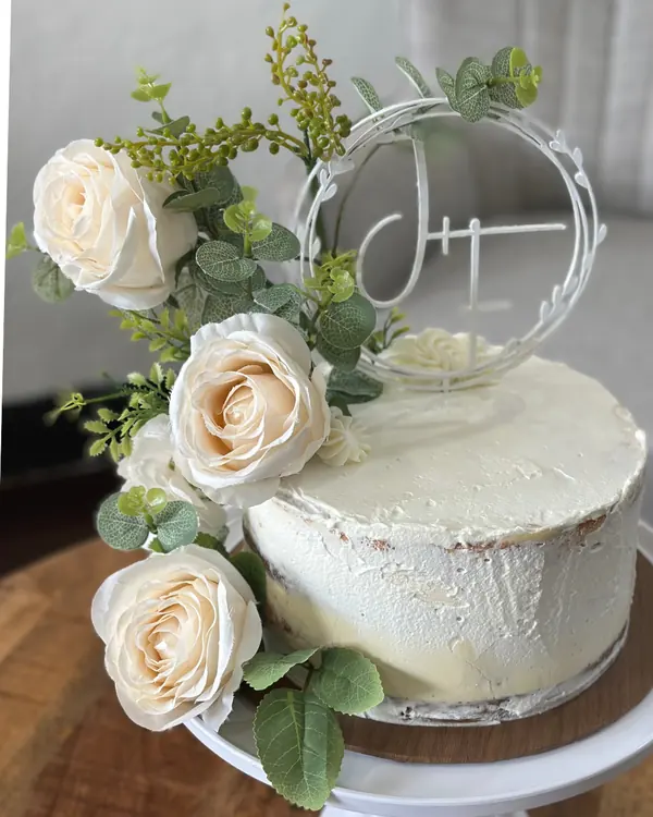 Tarta de boda blanca con rosas y topper con iniciales